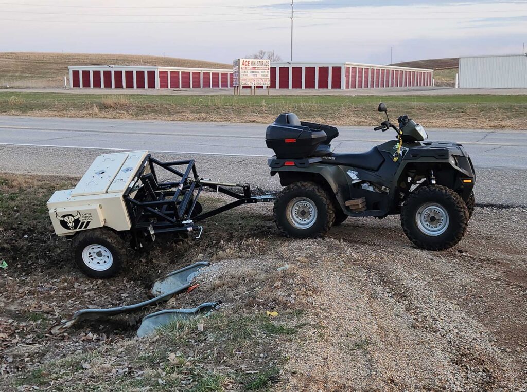 ATV with Dew Drop Drill attached in ditch